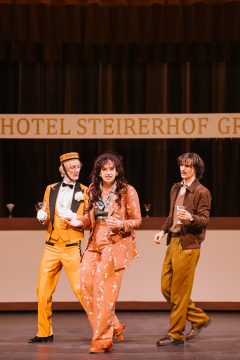 Foto mit 3 Personen vor einer Bar