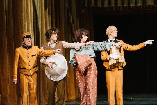 Foto mit 4 Personen, die alle nach rechts zeigen